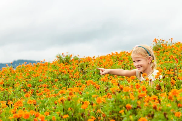 花の緑分野にまで引き上げた腕で幸せな子供. — ストック写真
