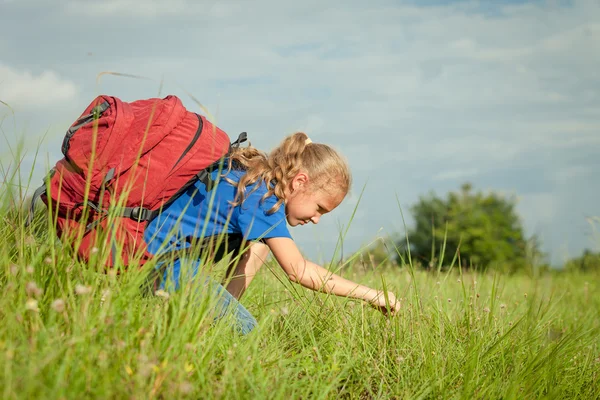 Teenager with a backpack sitting on the grass — Stock Photo, Image