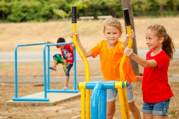 Twee gelukkige kleine meisjes op de speelplaats — Stockfoto