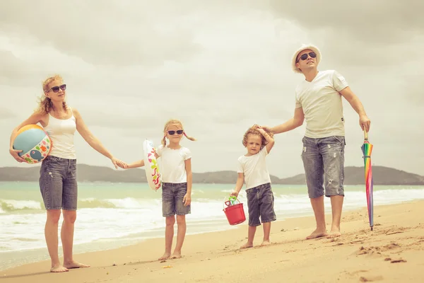 Gün zaman kumsalda mutlu aile ayakta. — Stockfoto