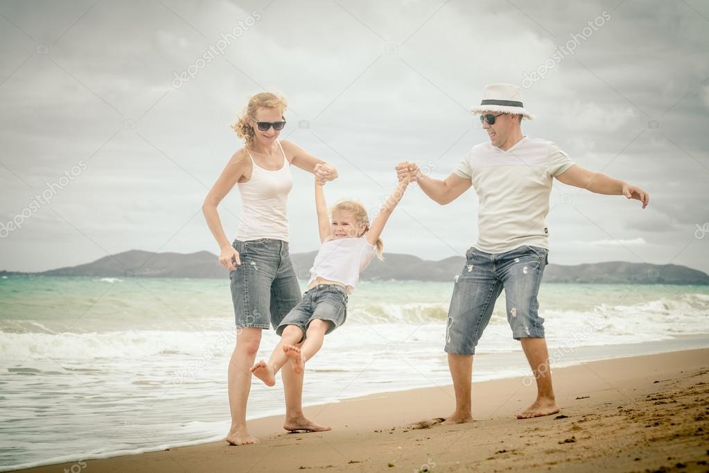 Happy family playing on the beach at the day time.
