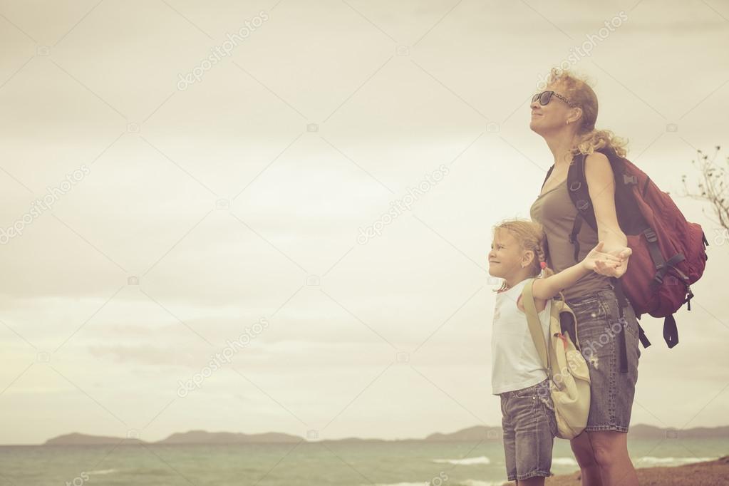 Happy family standing on the beach at the day time.