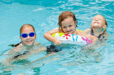 iki kızı ve küçük çocuk yüzme havuzunda oynamayı