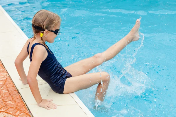 Kleines Mädchen sitzt in der Nähe von Schwimmbad — Stockfoto