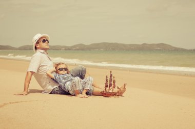 Baba ve oğul plaj gün anda oynamak.