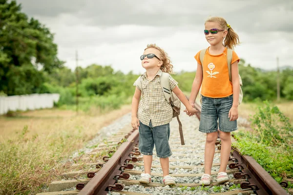 iki küçük çocuk-demiryolu üzerinde duran sırt çantası ile