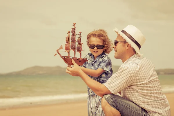 Padre e hijo jugando en la playa durante el día . — Foto de Stock