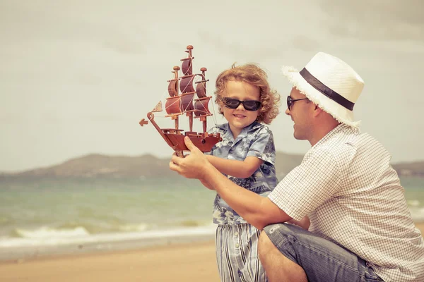 Padre e hijo jugando en la playa durante el día . — Foto de Stock