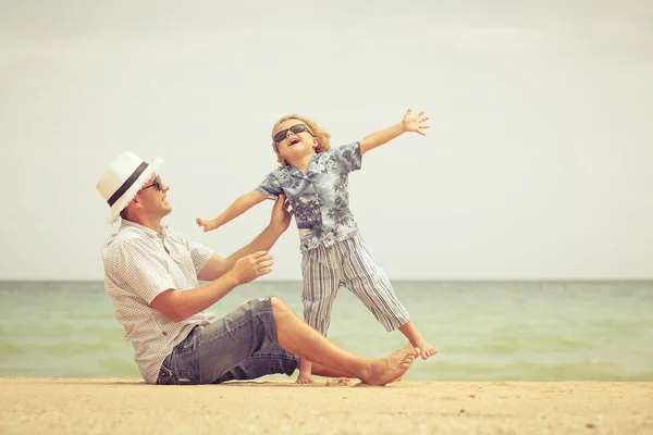 Pai e filho brincando na praia na hora do dia . — Fotografia de Stock