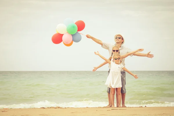 Gün zaman kumsalda mutlu aile ayakta. — Stockfoto