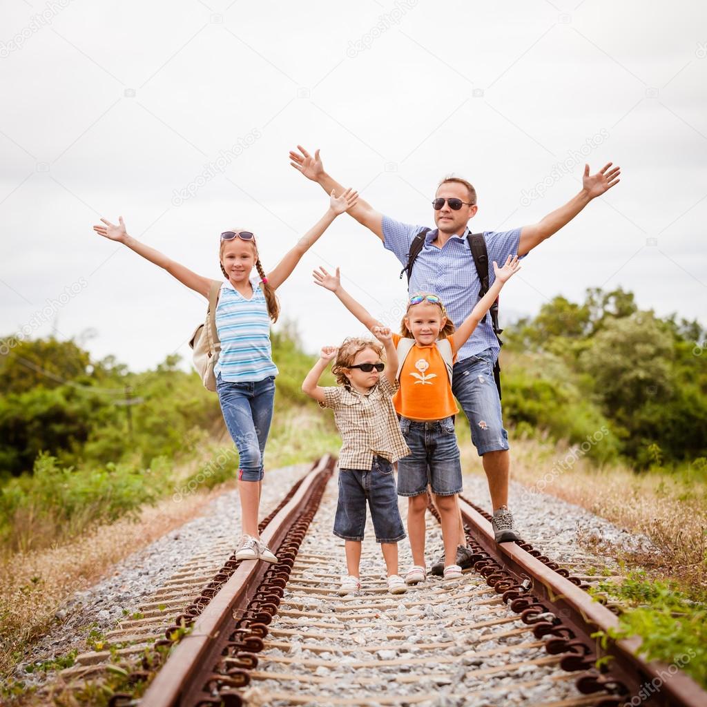 Happy family walking on the railway at the day time.