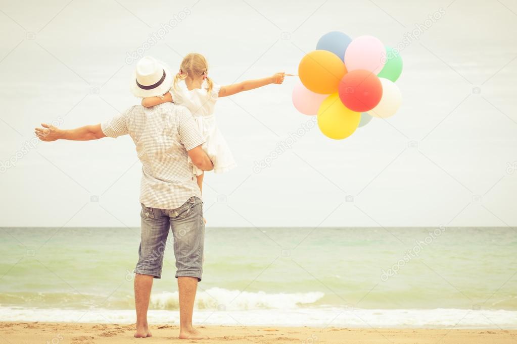 father and daughter playing on the beach at the day time