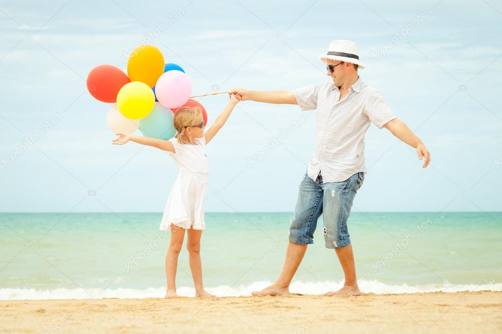 father and daughter playing on the beach at the day time