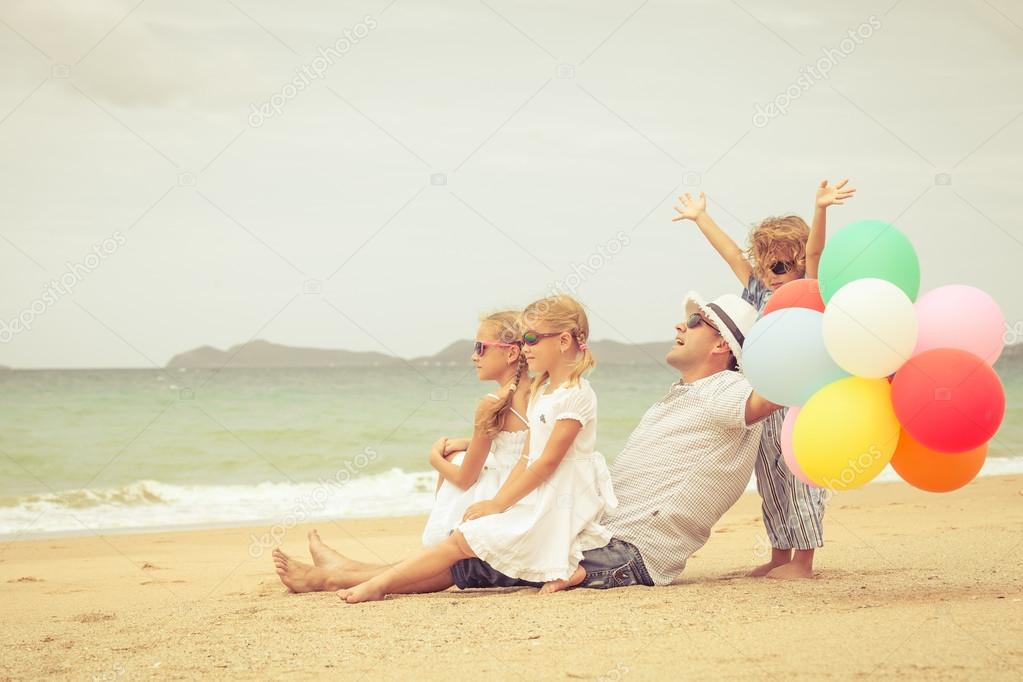 Happy family sitting on the beach at the day time.
