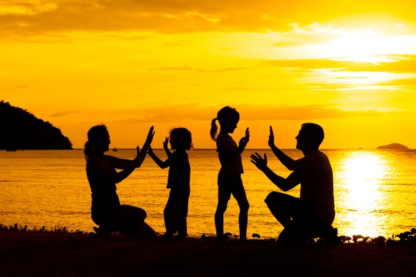 幸せな家族のシルエットで、sunse ビーチで遊んでいます。 — ストック写真