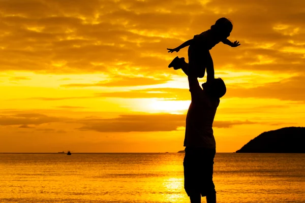 Far och dotter spelar på stranden vid solnedgången tid — Stockfoto