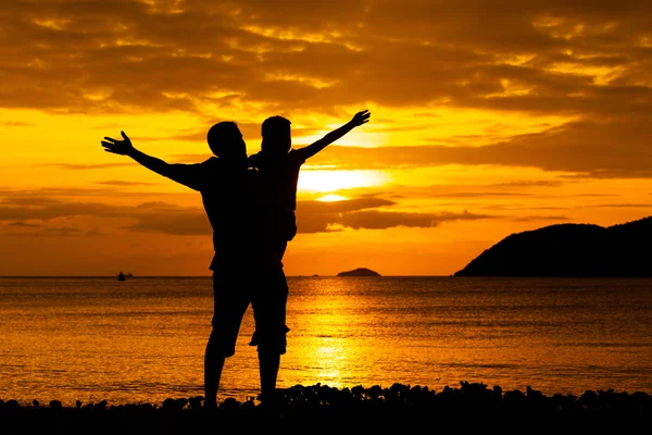 Vader en dochter spelen op het strand op de zonsondergang keer — Stockfoto