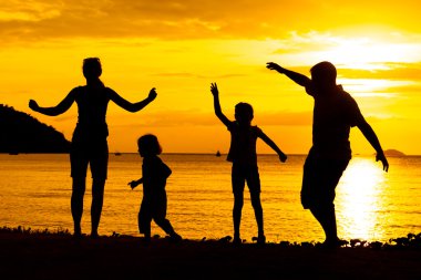mutlu aile silüeti sunse plajda oynayan