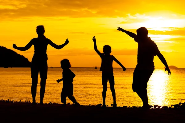 Silhouette of happy family who playing on the beach at the sunse — Stock Photo, Image