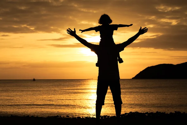 Father and son playing on the beach at the sunset time. — Zdjęcie stockowe