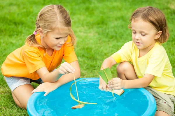 Fratello e sorella giocare con acqua vicino a una casa al giorno ti — Foto Stock