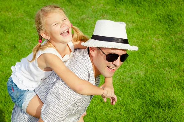 Portrait a father and daughter sitting on the grass at the day t — Stock Photo, Image