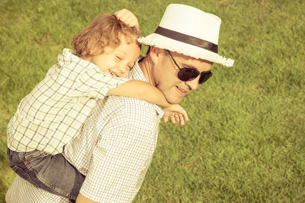 Retrato de um pai e filho sentado na grama no dia — Fotografia de Stock