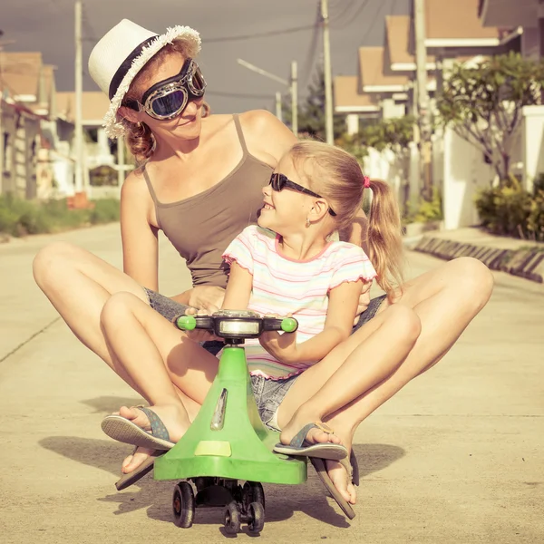 Mother and little daughter playing near a house at the day time. — Stock Photo, Image