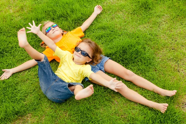 Enfants heureux assis sur l'herbe . — Photo