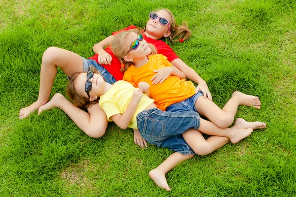 Gelukkige jonge geitjes zittend op het gras. — Stockfoto