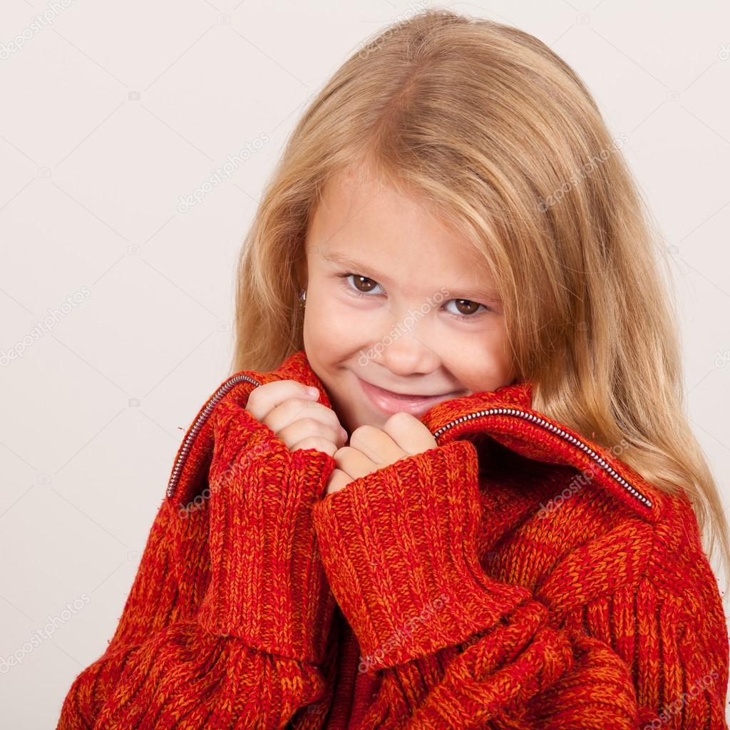 Portrait of a cute little girl in red sweater Stock Photo by ©altanaka