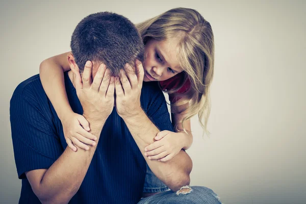 Portret van een triest dochter haar vader knuffelen — Stockfoto