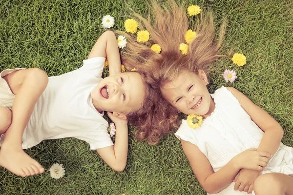 Menino e menina feliz deitado na grama — Fotografia de Stock