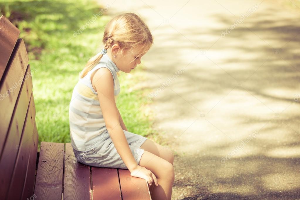 sad little girl sitting alone