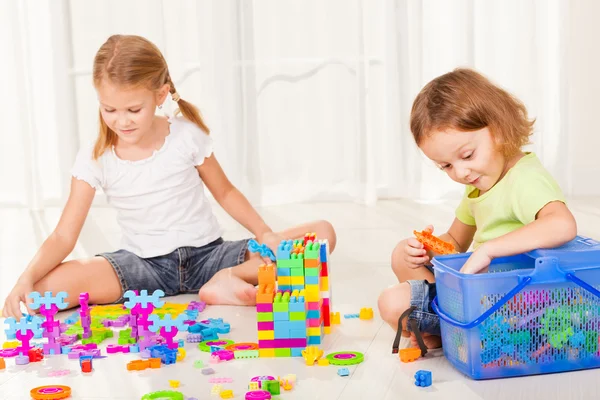 Menino e menina jogando Lego no chão — Fotografia de Stock