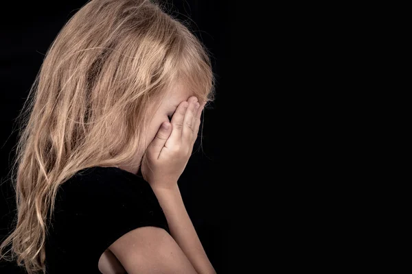 Retrato de triste menina loira em pé perto da parede — Fotografia de Stock