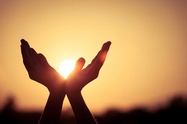 Silhouet van vrouwelijke handen tijdens zonsondergang — Stockfoto