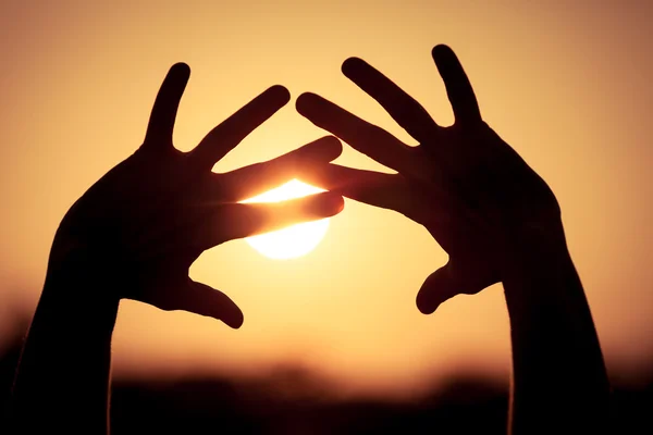 Silueta de las manos femeninas durante la puesta del sol — Foto de Stock