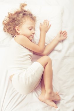 Evde yatakta yatan tatlı küçük çocuk