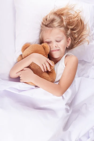 Милая маленькая девочка спит в постели дома — стоковое фото