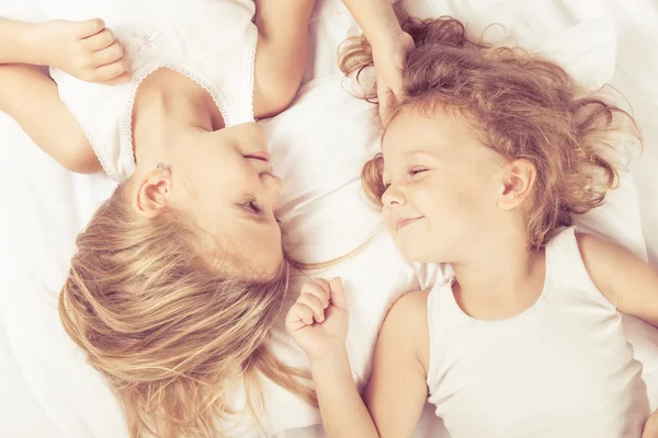 Lovely brother and sister lying in bed at home — Stock Photo, Image