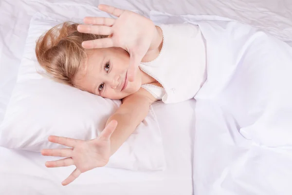 Linda menina deitada na cama em casa — Fotografia de Stock