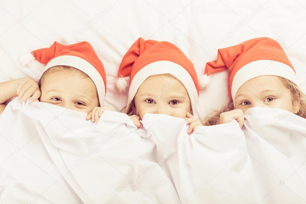 Lovely brother and sister lying in bed at home.