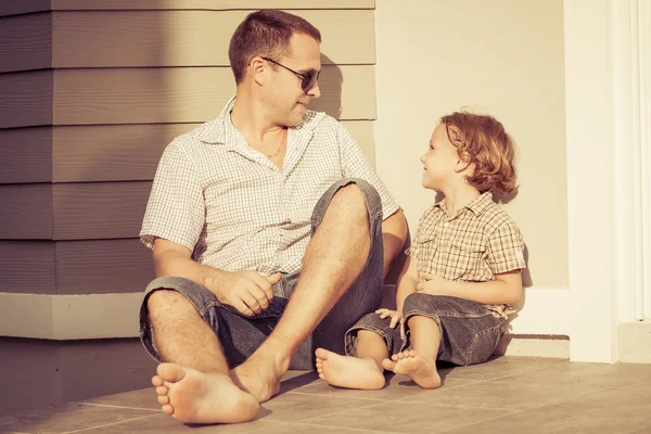 Pai e filho brincando perto de uma casa — Fotografia de Stock