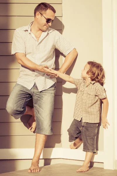 Pai e filho brincando perto de uma casa — Fotografia de Stock