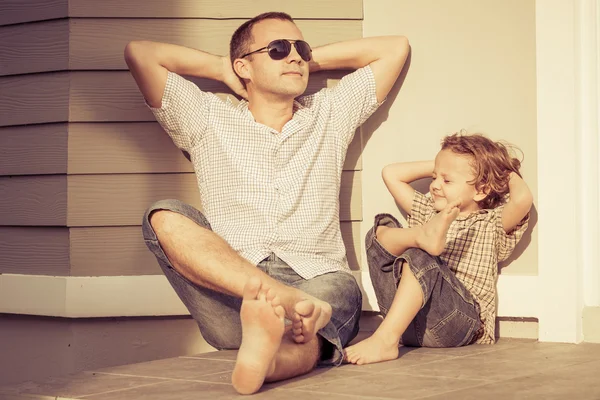 Papà e figlio giocano vicino a una casa Foto Stock