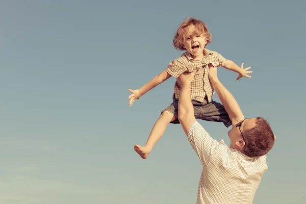 Papà e figlio giocano vicino a una casa Foto Stock