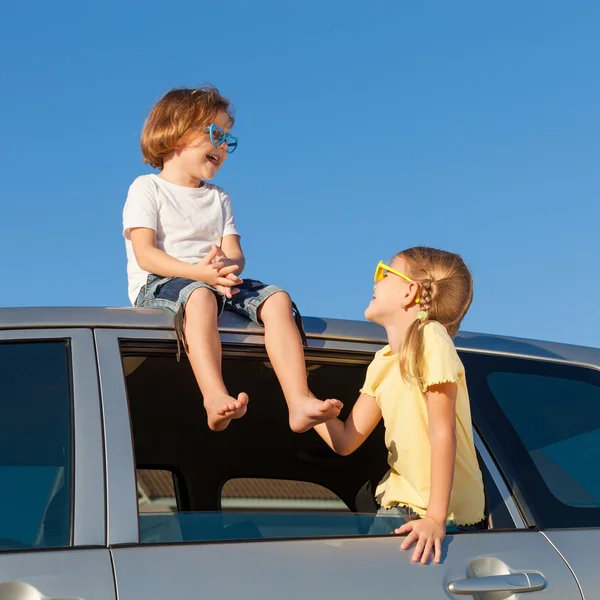 Happy brother and sister are sitting in the car — Stock Photo, Image