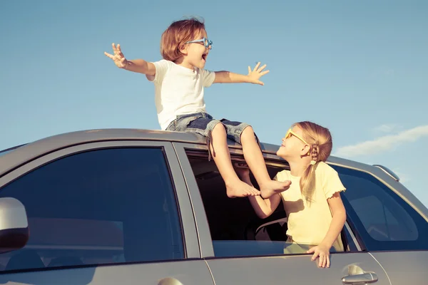 Happy brother and sister are sitting in the car — Stock Photo, Image