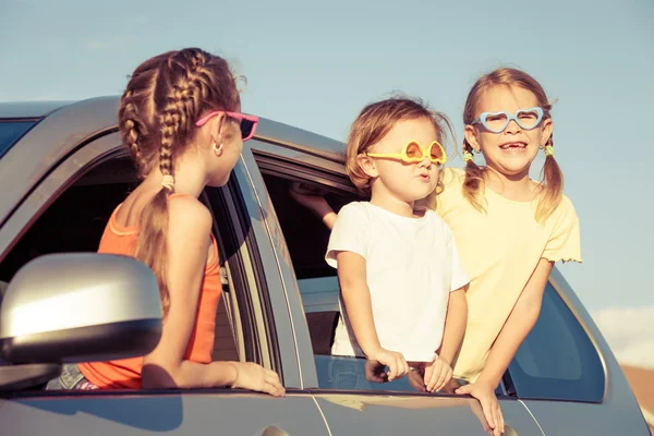 Irmão feliz e suas duas irmãs estão sentadas no carro — Fotografia de Stock